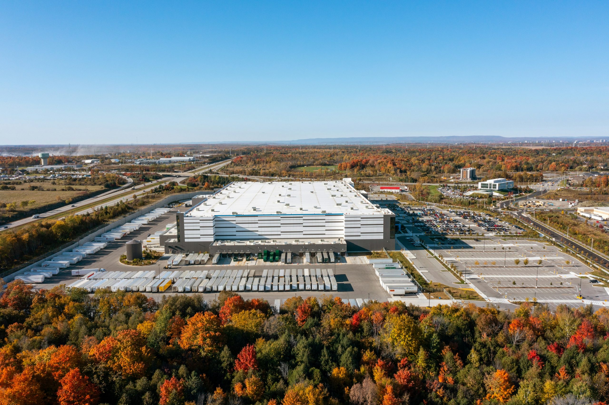 Luftaufnahme eines Logistikzentrums mit Laderampen und Fahrzeugen