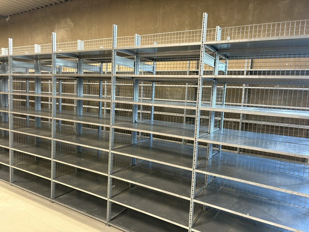 Stabiles Fachbodenregal aus verzinktem Stahl im Lager, ideal für Kleinteilelagerung und Kartons, montiert von Lagerteam in Hövelhof