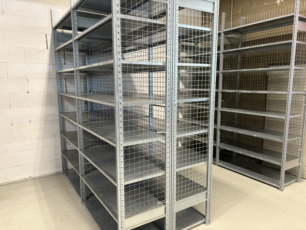 Fachbodenregale mit mehreren Ebenen und Gitterrückwänden zur sicheren Lagerung leichter Güter, montiert im Kundenlager von Lagerteam